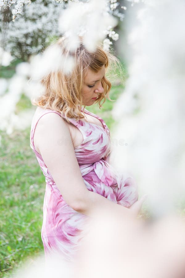 Pregnant woman standing near a flowering tree royalty free stock photos Pregnant woman standing near a flowering tree royalty free stock photos