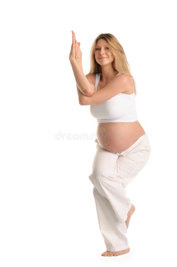 Pregnant woman standing and practicing yoga