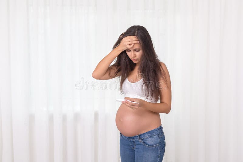 Pregnant woman with a thermometer in her bedroom. Pregnancy health and medcine contest. Illness, flu, allergy.