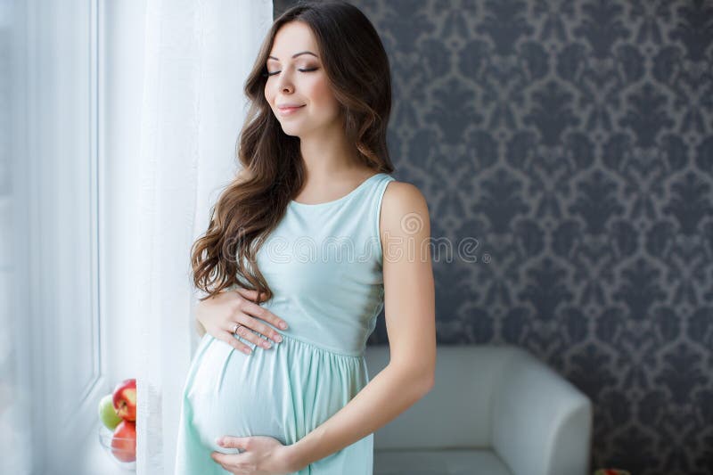 Pregnant woman touching hands big belly