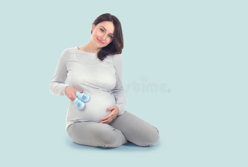 Pregnant Woman touching her belly. Pregnant middle aged mother`s hands caressing her tummy. Healthy Pregnancy concept