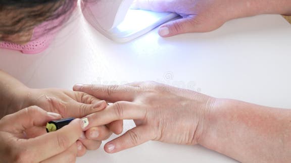Pinças de prego na mão do mestre manicure feminino colocando a toalha antes  de cuidar das unhas no salão de manicure.