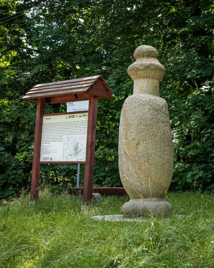 A prehistoric stone monk statue and information board on a tourist route to Sleza peak, Poland.