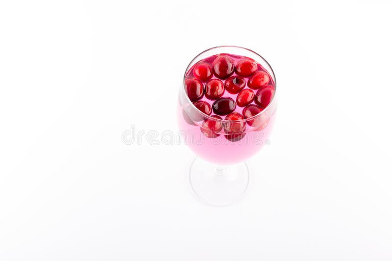 Preiselbeersaft mit Moosbeeren im Weinglas lokalisiert auf weißem Hintergrund lizenzfreie stockfotos