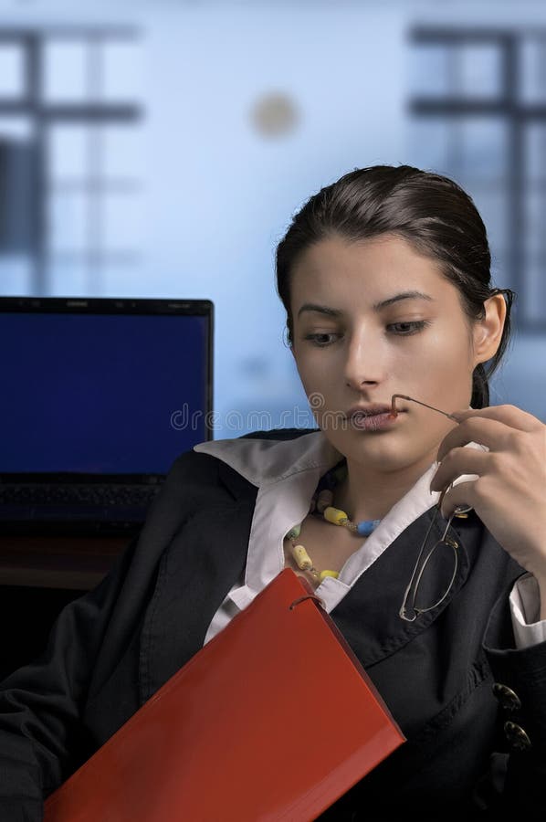 Premurosa imprenditrice che analizza documenti in ufficio fotografia stock libera da diritti