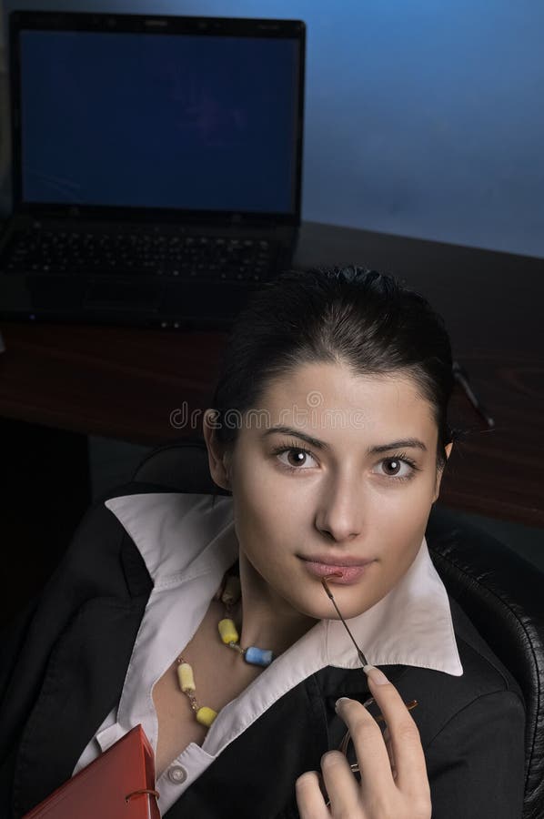 Premurosa imprenditrice che lavora fino a tardi in ufficio fotografia stock libera da diritti