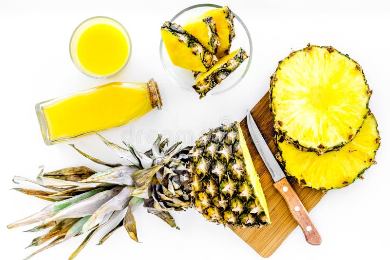 Preparando o suco de abacaxi Corte fatias de abacaxi com uma faca na opinião superior do fundo branco fotografia de stock Preparando o suco de abacaxi Corte fatias de abacaxi com uma faca na opinião superior do fundo branco fotografia de stock