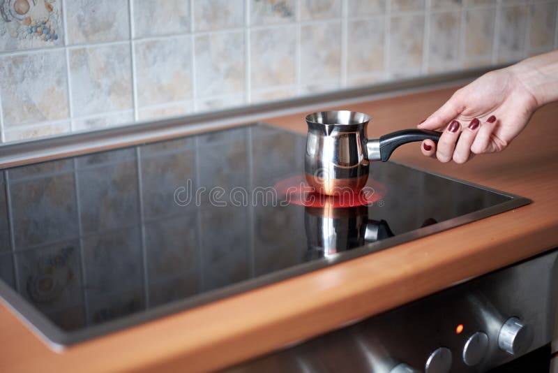Prepararea cafelei în curcanul tradițional din cupru pe un cuptor de bucătărie interior stock images