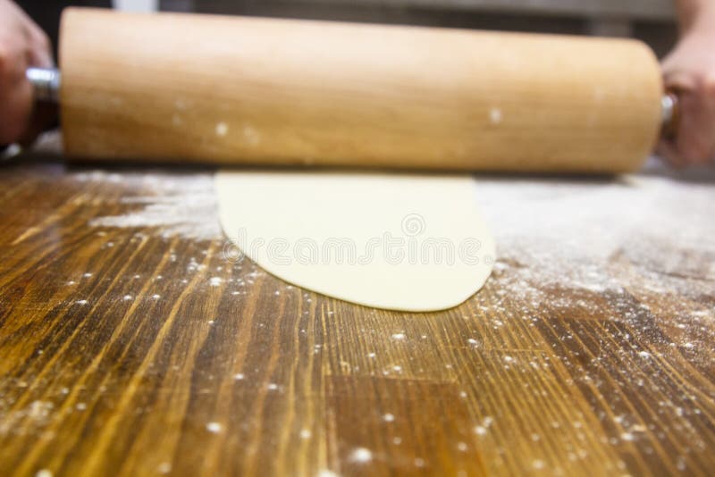 Preparation of the Dough. Cook Rolls Out the on the Board. Stock Photo