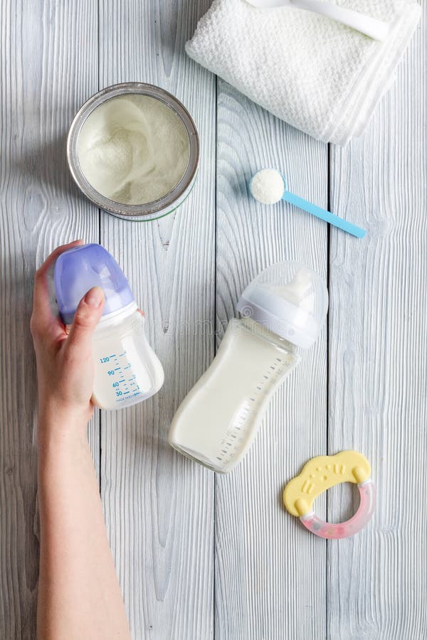 Preparation of mixture baby feeding on wooden background top view