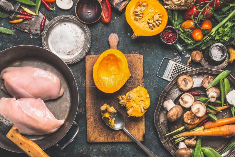 Preparação com abóbora, vegetais e ingredientes dos cogumelos com o peito de frango em cozinhar o potenciômetro, fundo rústico es foto de stock royalty free Preparação com abóbora, vegetais e ingredientes dos cogumelos com o peito de frango em cozinhar o potenciômetro, fundo rústico es foto de stock royalty free