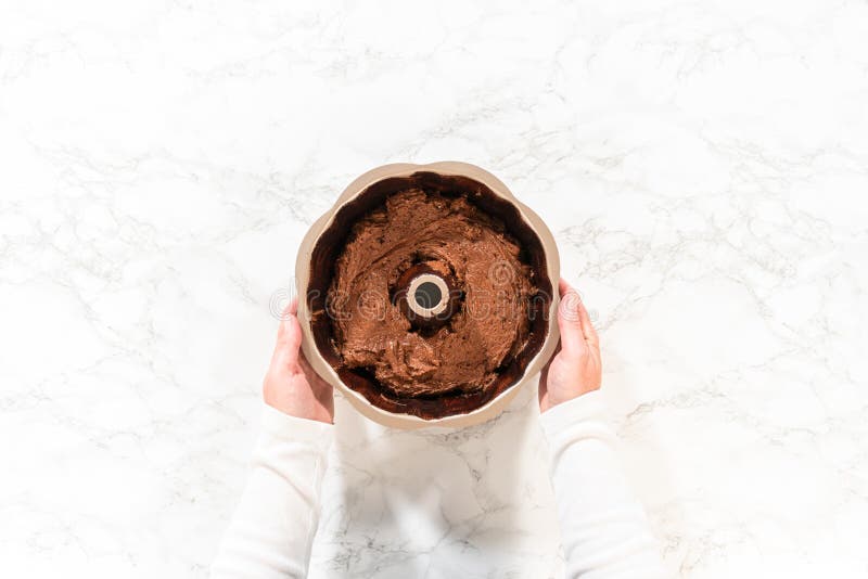 Flat lay. The prepared batter is carefully filled into the greased bundt pan - setting the stage for a delicious Chocolate Bundt Cake. Flat lay. The prepared batter is carefully filled into the greased bundt pan - setting the stage for a delicious Chocolate Bundt Cake.