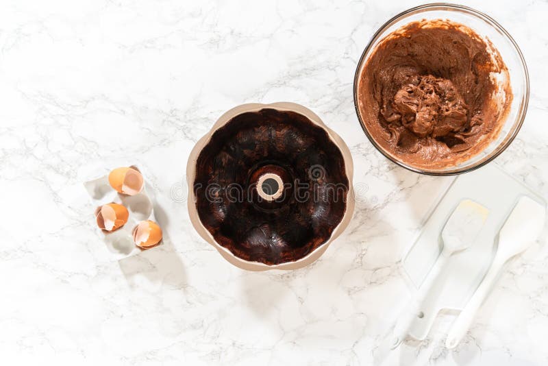 Flat lay. The prepared batter is carefully filled into the greased bundt pan - setting the stage for a delicious Chocolate Bundt Cake. Flat lay. The prepared batter is carefully filled into the greased bundt pan - setting the stage for a delicious Chocolate Bundt Cake.
