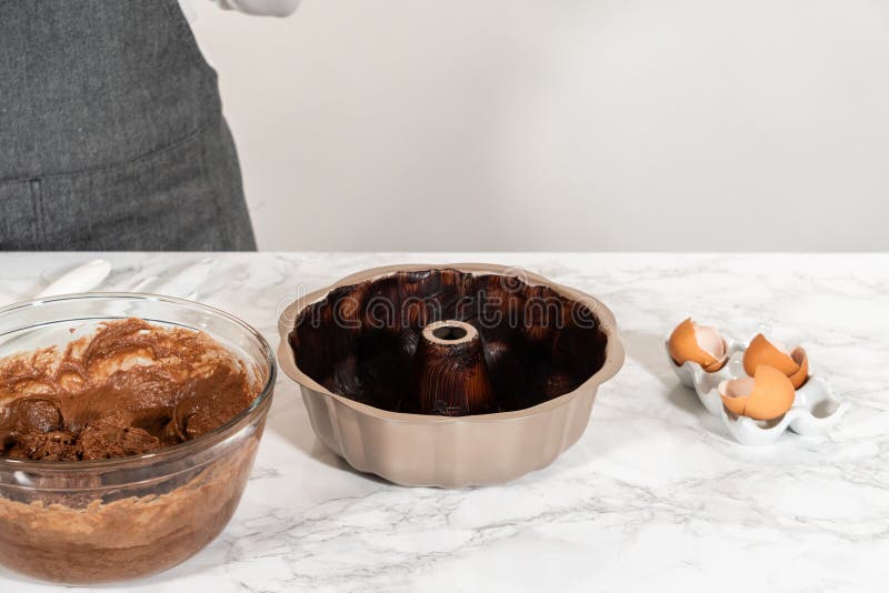 The prepared batter is carefully filled into the greased bundt pan - setting the stage for a delicious Chocolate Bundt Cake. The prepared batter is carefully filled into the greased bundt pan - setting the stage for a delicious Chocolate Bundt Cake.