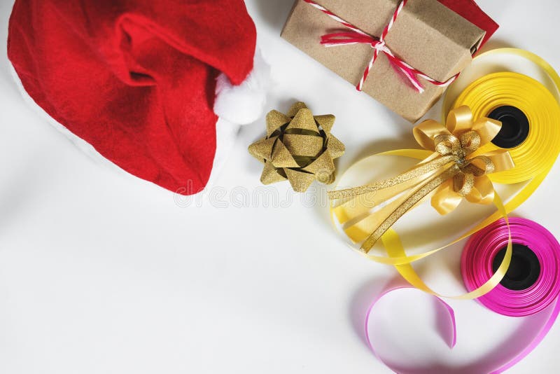 Preparação dos presentes do Natal na tabela branca com espaço da cópia Chapéu vermelho de Santa com caixa de presente e a fita co fotografia de stock Preparação dos presentes do Natal na tabela branca com espaço da cópia Chapéu vermelho de Santa com caixa de presente e a fita co fotografia de stock