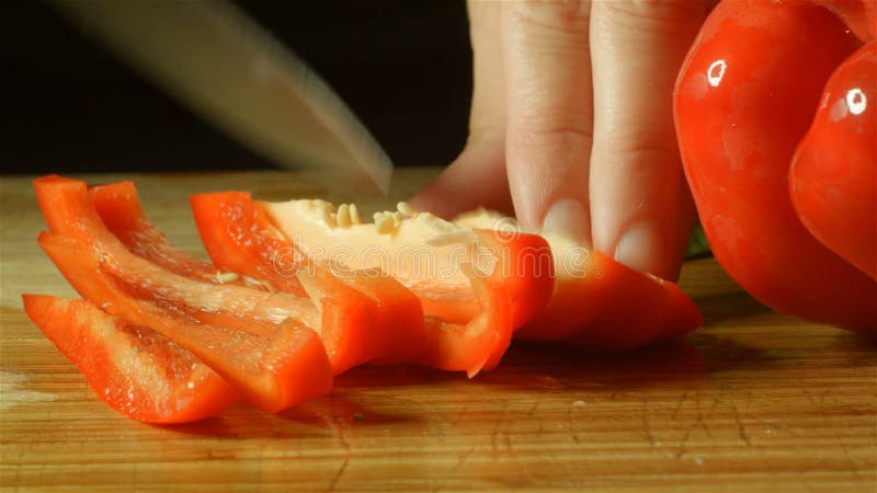 Preparação vermelha fresca saudável do alimento da pimenta do capsicum que corta acima na cozinha