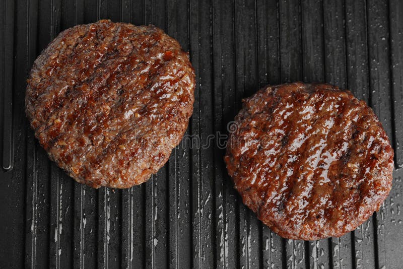 Prepared meat cutlets for burger on grill