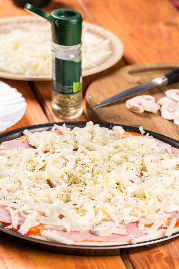 Prepared Raw Pizza Ready for Baking with Grated Cheese Ham Mushrooms