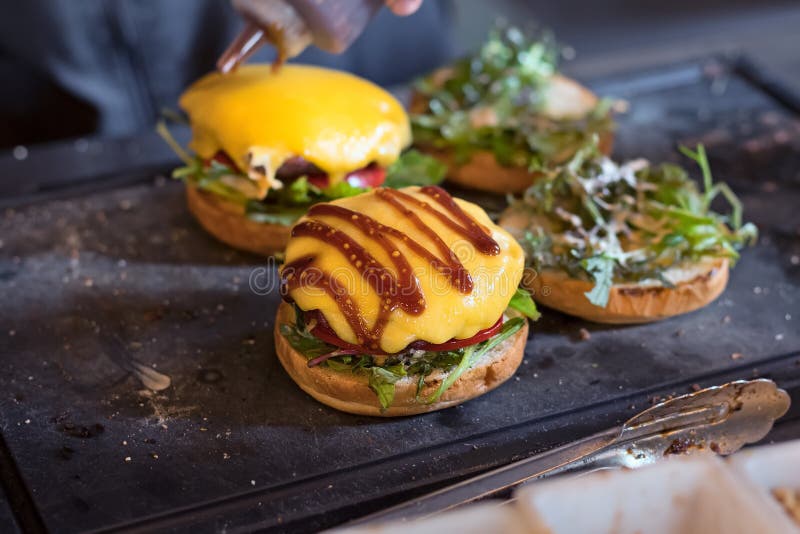 Preparing Burger Adding the Sauce on the Cream Cheese. Three Burgers