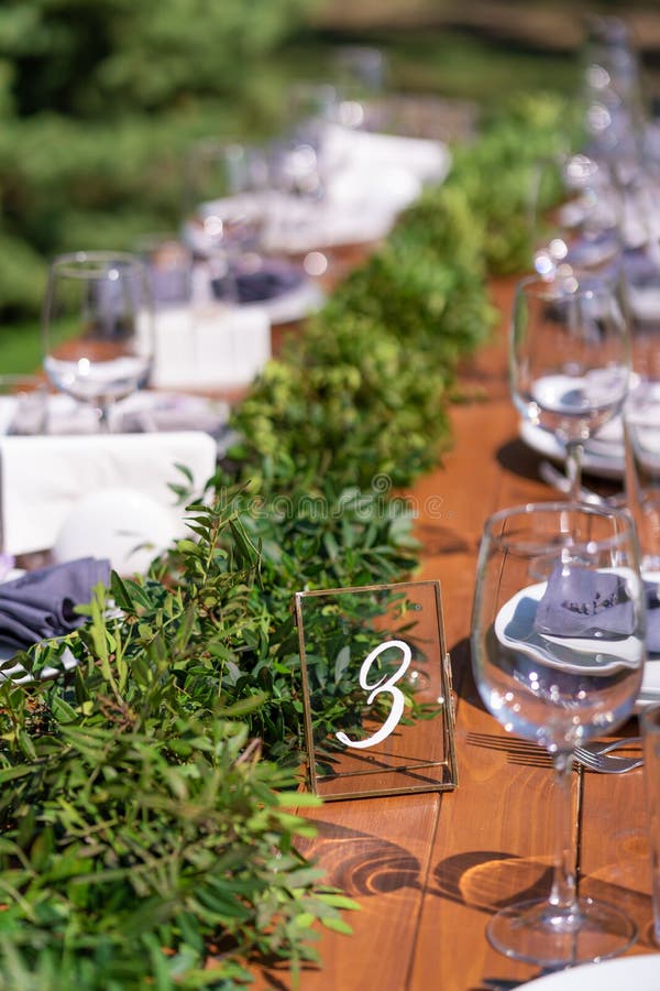Preparing for an open-air party. Decorated with fresh flowers served tables. Table number. Decoration Details stock photography Preparing for an open-air party. Decorated with fresh flowers served tables. Table number. Decoration Details stock photography