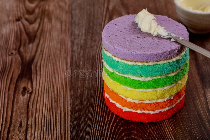 Preparing rainbow sponge cake for birthday party stock photo