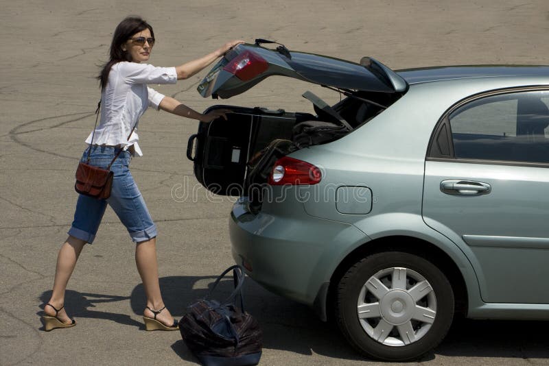 Donna di carico bagagli in auto, la preparazione per il viaggio.