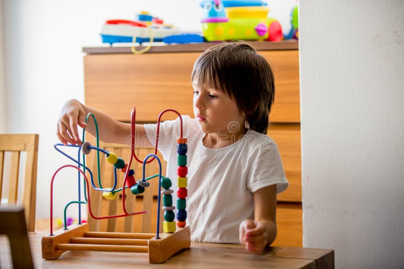 Preschool dziecko, bawić się z zabawkami w pogodnym pokoju zdjęcie stock Preschool dziecko, bawić się z zabawkami w pogodnym pokoju zdjęcie stock