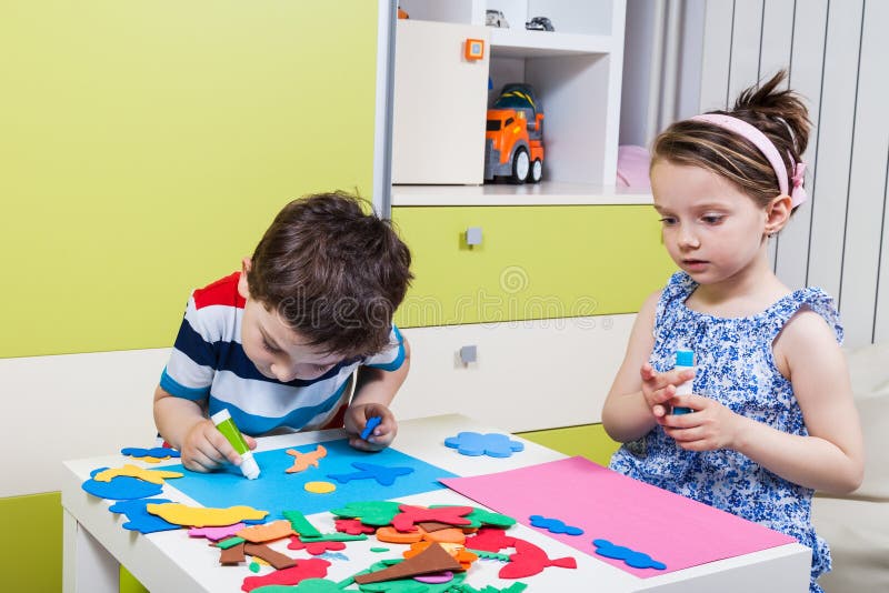 Preschool dziecko tworzy obrazek z piankowymi kształtami fotografia stock Preschool dziecko tworzy obrazek z piankowymi kształtami fotografia stock