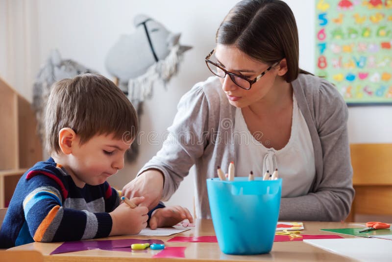 Preschool teacher with child at Kindergarten - Creative Art Class stock photos