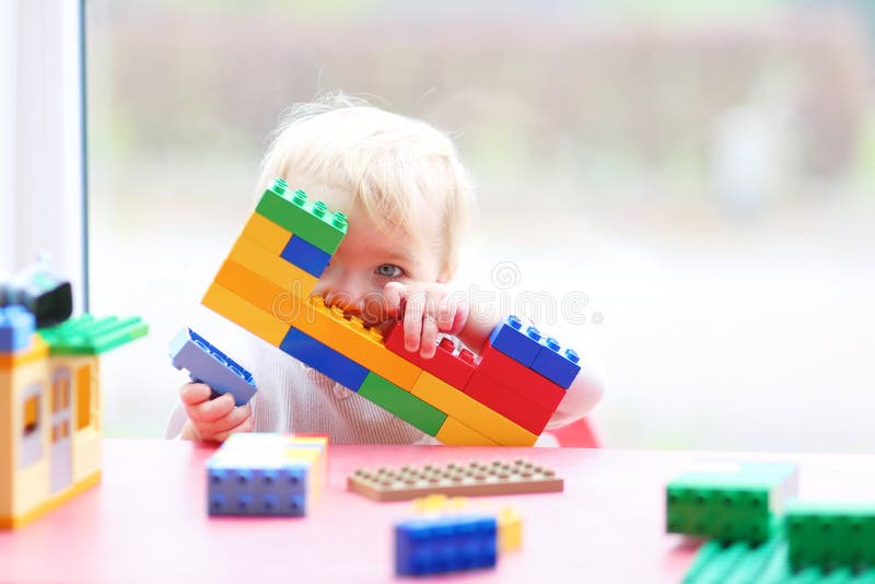 Preschooler girl building from plastic bricks