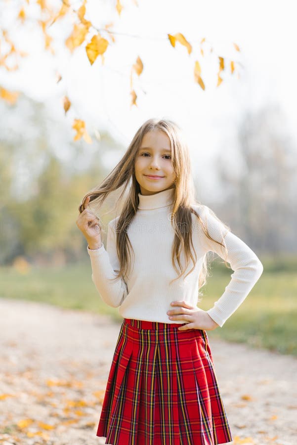 A Girl in a School Red Plaid Skirt Walks through the Autumn Forest ...