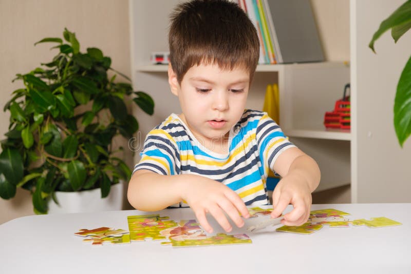 A Preschooler Plays Puzzles, Puts Together a Picture Stock Image