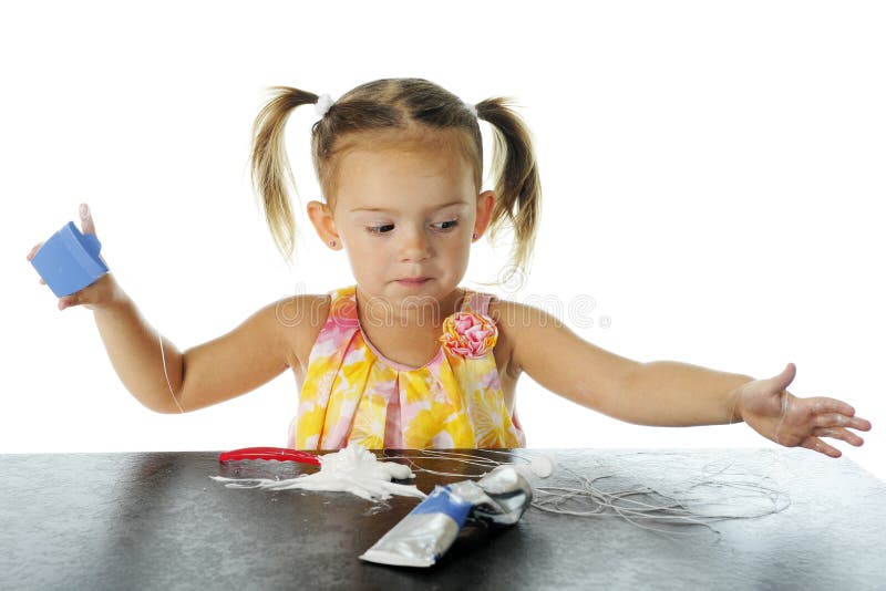 An adorable preschooler emptying the floss container as she has already done with a tube of toothpaste. On a white background. An adorable preschooler emptying the floss container as she has already done with a tube of toothpaste. On a white background.