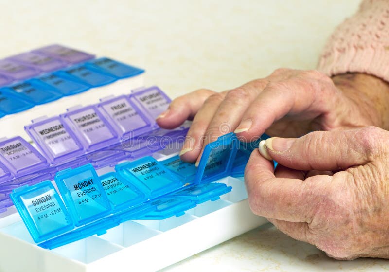 Prescription Drugs In Organizer With Elderly Hands royalty free stock image Prescription Drugs In Organizer With Elderly Hands royalty free stock image