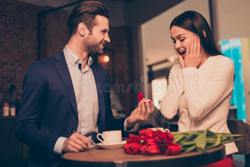 Making proposal in a cafe with ring and flowers unexpected moment honeymoon jewelry ring diamond golden concept wife husband. Making proposal in a cafe with ring and flowers unexpected moment honeymoon jewelry ring diamond golden concept wife husband.