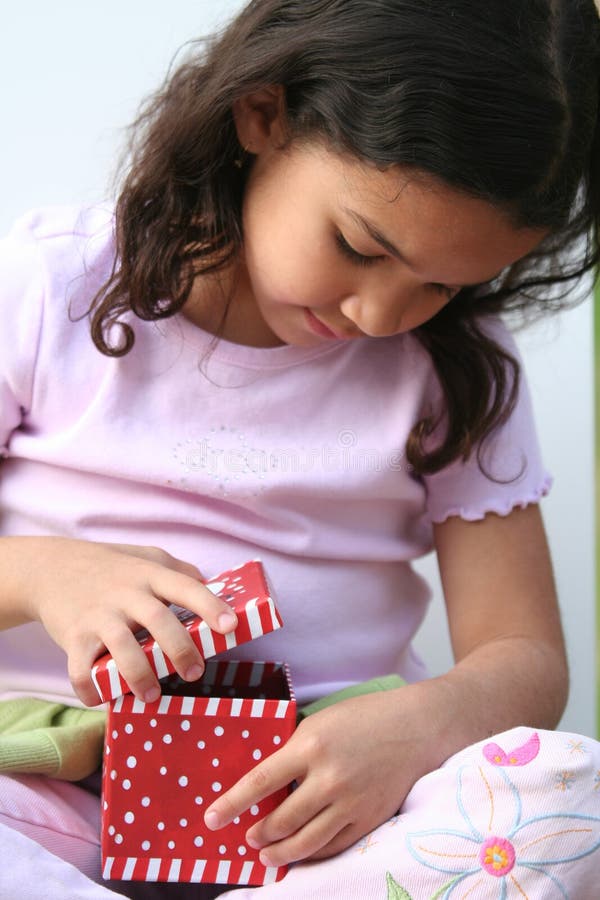 Young girl on white background opening a christmas present. Young girl on white background opening a christmas present