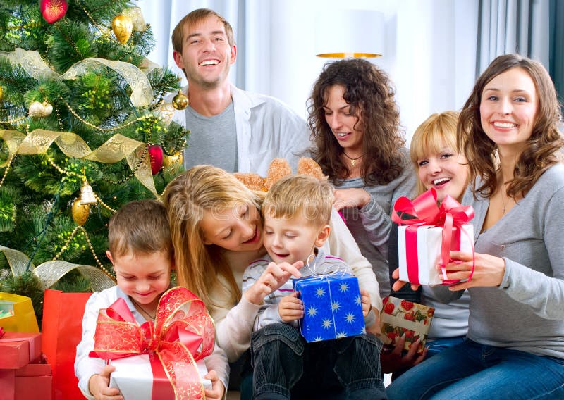 Presentes de Natal grandes felizes da terra arrendada da família no hom imagem de stock