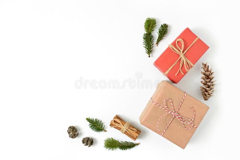 Presentes do Natal envolvidos no ofício marrom e papel vermelho decorado com ramos do abeto e do pinho e cones isolados no backgr fotografia de stock Presentes do Natal envolvidos no ofício marrom e papel vermelho decorado com ramos do abeto e do pinho e cones isolados no backgr fotografia de stock