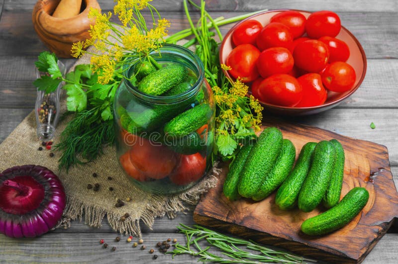 Preservar los tomates frescos y conservados en vinagre de los pepinos fotografía de archivo libre de regalías Preservar los tomates frescos y conservados en vinagre de los pepinos fotografía de archivo libre de regalías