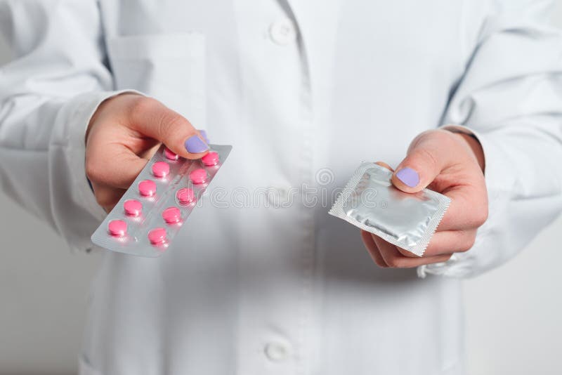 Preservativos e contraceptivos nas mãos de um doutor para o sexo seguro imagem de stock royalty free Preservativos e contraceptivos nas mãos de um doutor para o sexo seguro imagem de stock royalty free