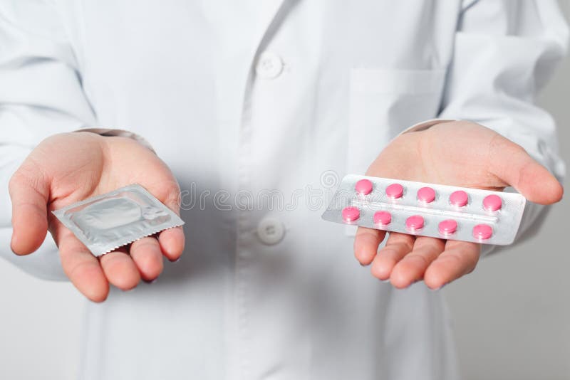 Preservativos e contraceptivos nas mãos de um doutor para o sexo seguro