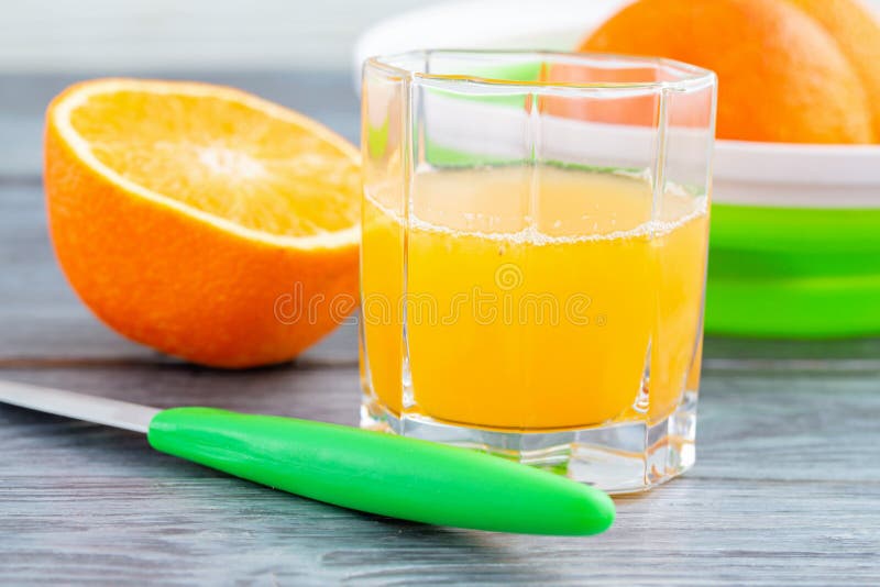 Pressade nytt orange fruktsaft i en exponeringsglaskopp på en trätabell arkivfoton Pressade nytt orange fruktsaft i en exponeringsglaskopp på en trätabell arkivfoton