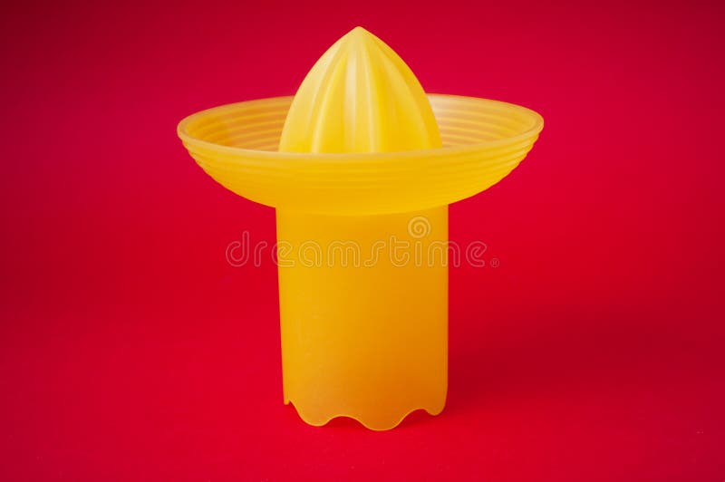 Presse-fruits jaune de fruit sur le fond rouge images stock Presse-fruits jaune de fruit sur le fond rouge images stock
