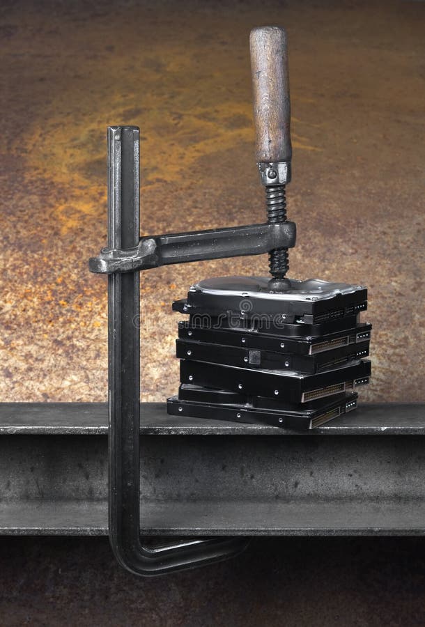 Clamp Pressing On Stack Of Hard Drives. Rusty Background Stock