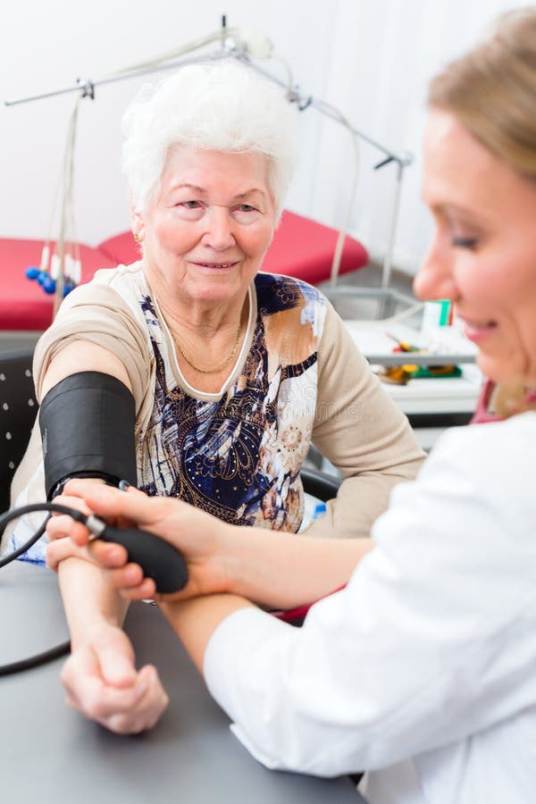Pressione sanguigna di misurazione di medico del paziente senior immagine stock libera da diritti Pressione sanguigna di misurazione di medico del paziente senior immagine stock libera da diritti