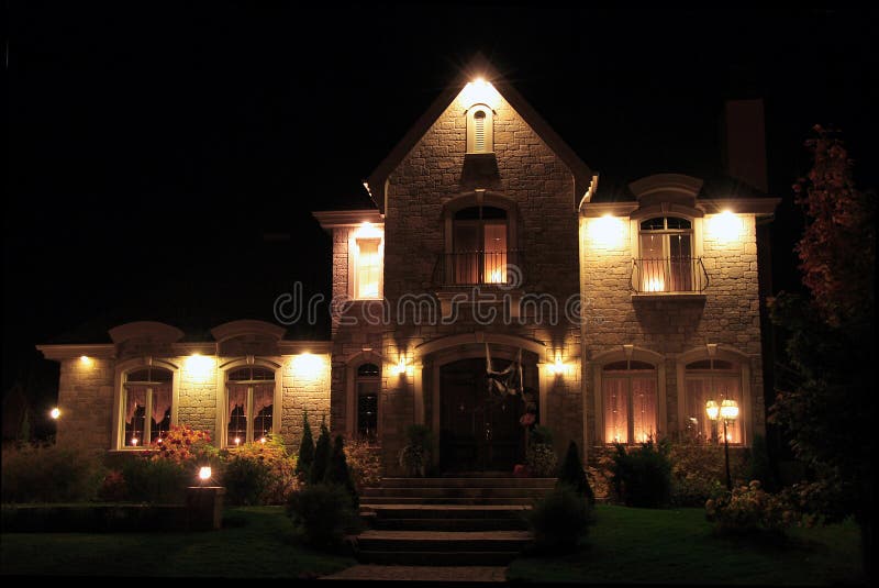 Illuminated, prestigious new house at night. Some Halloween decorations can be seen. Illuminated, prestigious new house at night. Some Halloween decorations can be seen.