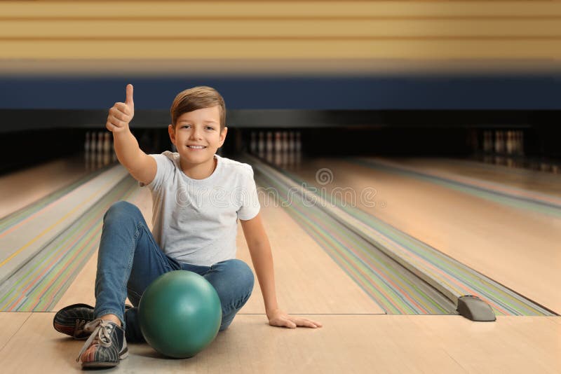 Preteen boy with ball in bowling