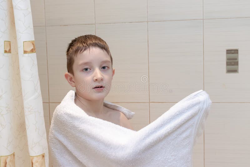 A preteen boy drying his hair with white towel - children, kid independence concept