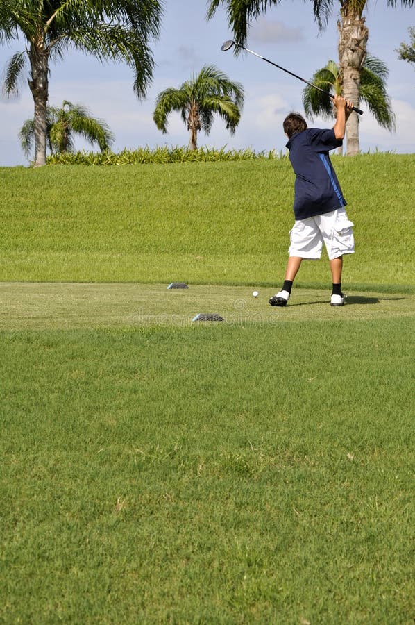Preteen boy golfing stock photo