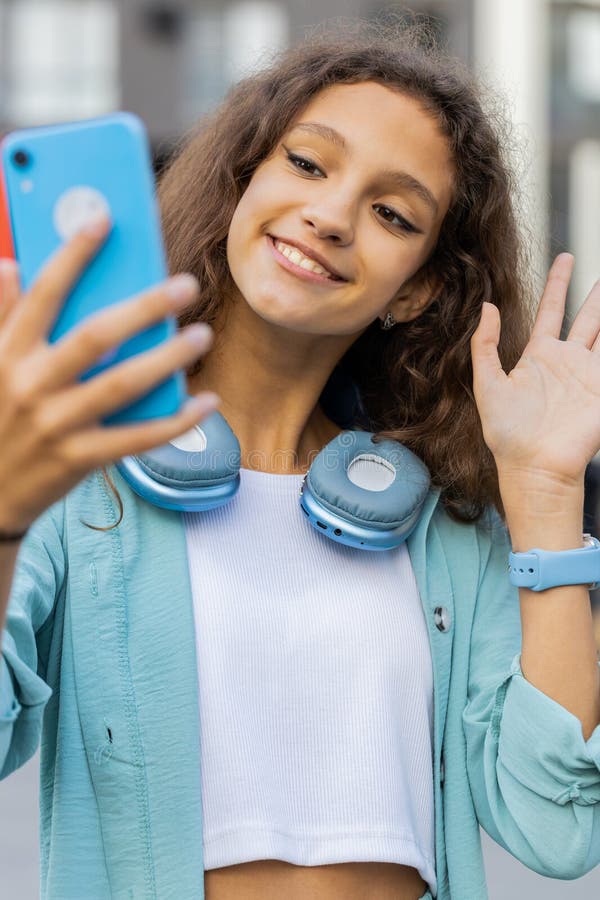 Preteen girl blogger prendre selfie sur smartphone vidéo appel en ligne avec des abonnés à city street images stock